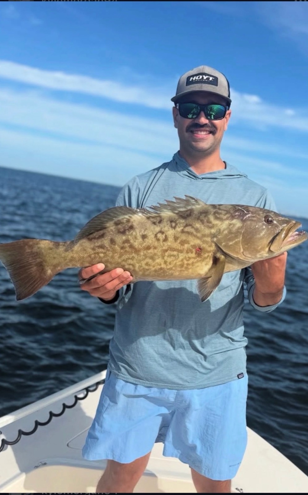 Happy client holding a fish